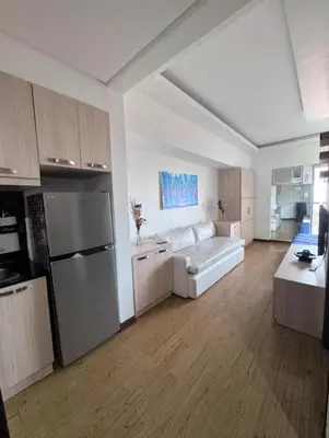 a large living room with a couch and a kitchen at Chelsea Tower by Calvin in Manila