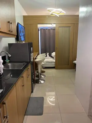 a kitchen with a sink and a room with a bed at RJ Shell Staycation -PD in Manila