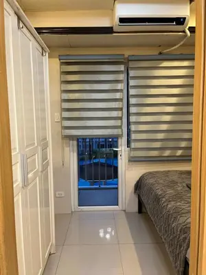 a bedroom with a bed and a window with blinds at RJ Shell Staycation -PD in Manila