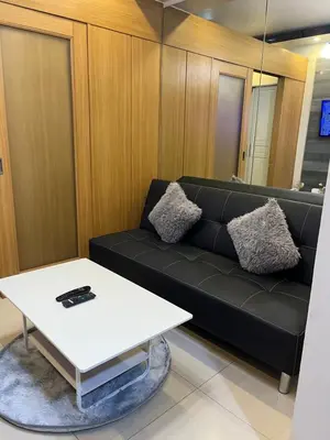 a living room with a black couch and a white table at RJ Shell Staycation -PD in Manila