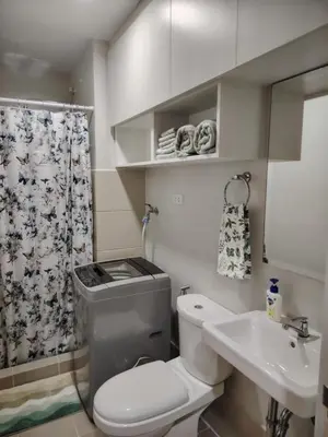 a small bathroom with a toilet and a sink at 2BR Condo SMDC Charm Metro Manila in Manila