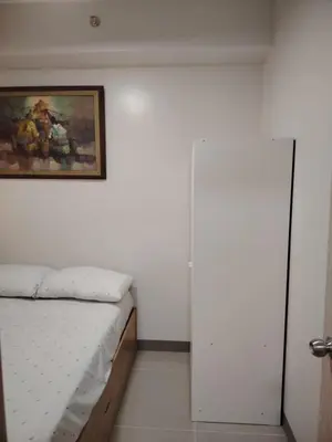 a bedroom with a bed and a painting on the wall at 2BR Condo SMDC Charm Metro Manila in Manila