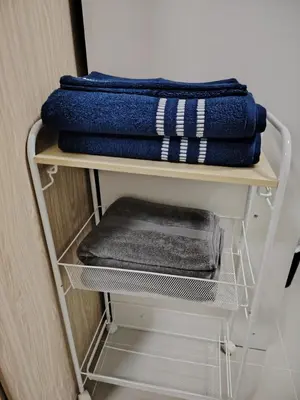 a white shelf with blue towels on top of it at 2BR Mountain View Condo SMDC Charm Metro Manila in Manila
