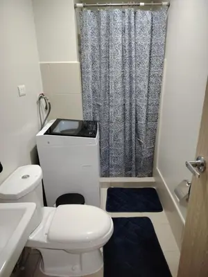 a small bathroom with a toilet and a shower at 2BR Mountain View Condo SMDC Charm Metro Manila in Manila