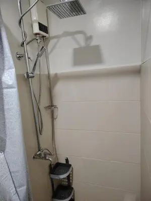 a bathroom with a shower with a shower curtain at 2BR Mountain View Condo SMDC Charm Metro Manila in Manila