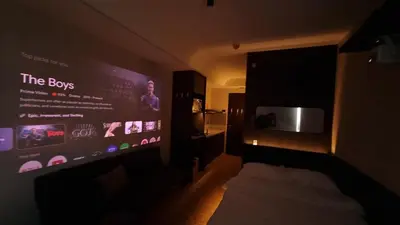a dark room with a bed and a large screen at Highwind - Projector, Playstation 4, Pool in Silang