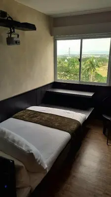 a bedroom with a bed with a large window at Highwind - Projector, Playstation 4, Pool in Silang