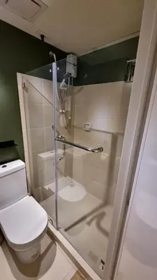 a bathroom with a toilet and a glass shower at Highwind - Projector, Playstation 4, Pool in Silang