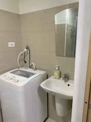 a white bathroom with a sink and a mirror at Olivia in Manila