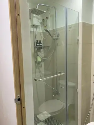 a glass shower in a bathroom with a toilet at Olivia in Manila