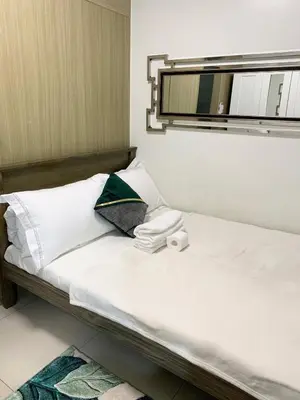 a bedroom with a bed with a mirror on the wall at Olivia in Manila