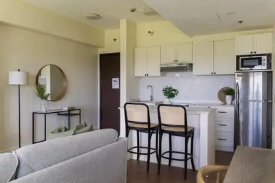 a kitchen and living room with a couch and a table at Elegant and Modern 2 BR Home Golf Skyline View in Manila