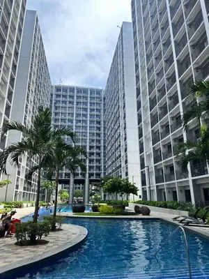 a swimming pool in front of two tall buildings at The Hideout Condotel in Shore 2 Residences Tower 3 in Manila