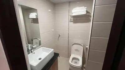 a white bathroom with a sink and a toilet at Bayport West Naia Residences in Manila