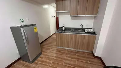 a small kitchen with a sink and a refrigerator at Bayport West Naia Residences in Manila