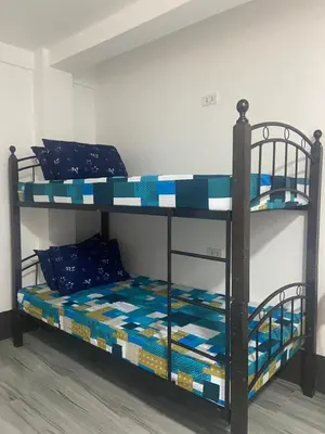 two bunk beds in a room with blue pillows at Marites Guesthouse in General Trias