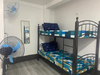 a room with two bunk beds and a fan at Marites Guesthouse in General Trias
