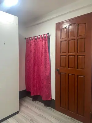 a room with a red curtain next to a door at Marites Guesthouse in General Trias