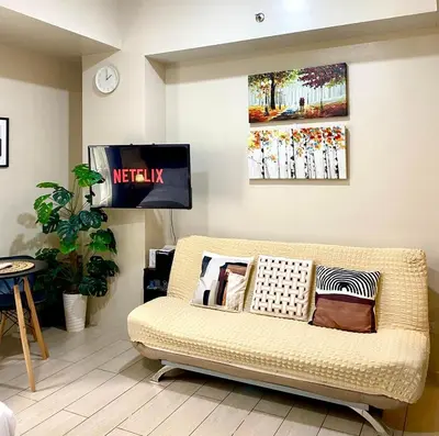 a living room with a couch and a tv at Azure Staycation - Pablo's Suites in Manila