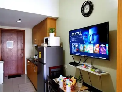 a kitchen with a large tv on the wall at Azure Staycation - Pablo's Suites in Manila