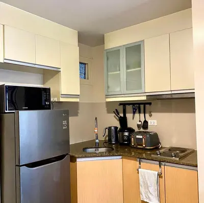 a kitchen with a stainless steel refrigerator and cabinets at Azure Staycation - Pablo's Suites in Manila