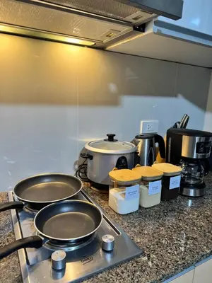 a kitchen counter with pots and pans on a stove at Cozy Haven - Newport - Walking distance to NAIA T3 in Sampong