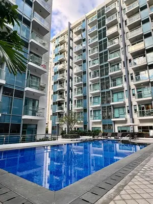 a swimming pool in front of a large apartment building at Cozy Haven - Newport - Walking distance to NAIA T3 in Sampong