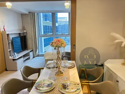 a dining room with a table with a vase of flowers at Luxurious & Elegant Unit in Parksuites BGC in Manila