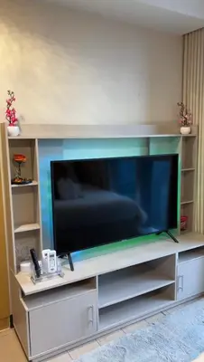 a large flat screen tv sitting on a entertainment center at Luxurious & Elegant Unit in Parksuites BGC in Manila