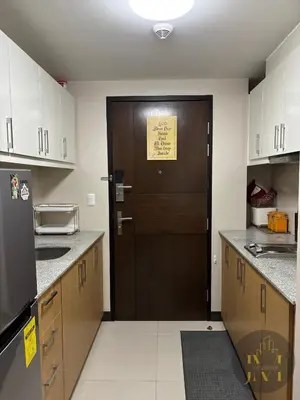 a kitchen with a brown door with a yellow sign on it at Luxurious & Elegant Unit in Parksuites BGC in Manila