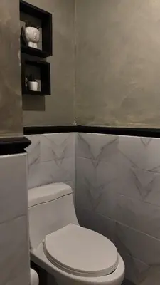 a bathroom with a white toilet in a room at The Monochrome Nest in Manila