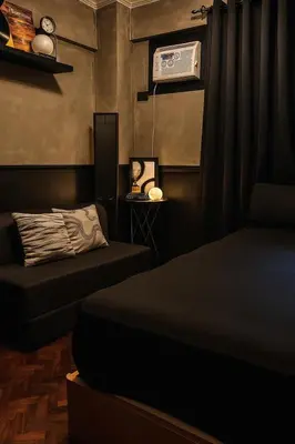 a bedroom with two beds and a air conditioner at The Monochrome Nest in Manila