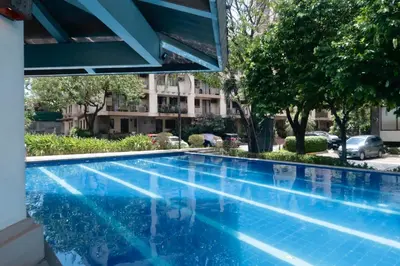 a blue swimming pool with a building in the background at The Monochrome Nest in Manila