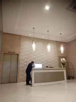 a man standing at a reception desk in a lobby at 150 Newport Boulevard in Manila