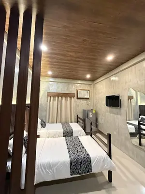 a bedroom with two beds and a tv in it at HM Eco Hotel NAIA in Manila