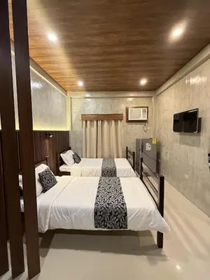 a bedroom with two beds and a flat screen tv at HM Eco Hotel NAIA in Manila