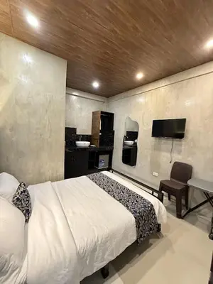 a bedroom with a bed and a sink and a tv at HM Eco Hotel NAIA in Manila