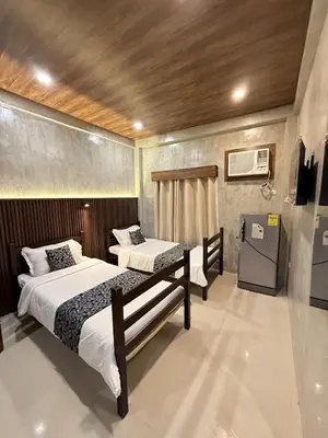 a bedroom with two beds and a refrigerator at HM Eco Hotel NAIA in Manila