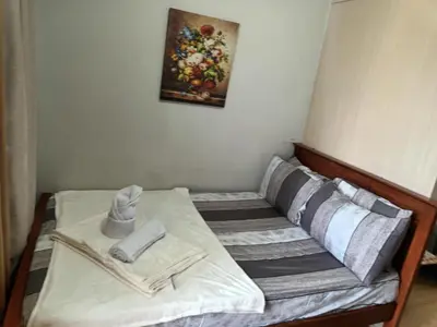 a bed with two towels and a picture on the wall at Sea Residences LJ Place in Manila
