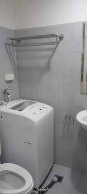 a white bathroom with a toilet and a sink at Sea Residences LJ Place in Manila