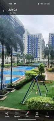 a playground in front of a pool with palm trees at Sea Residences LJ Place in Manila