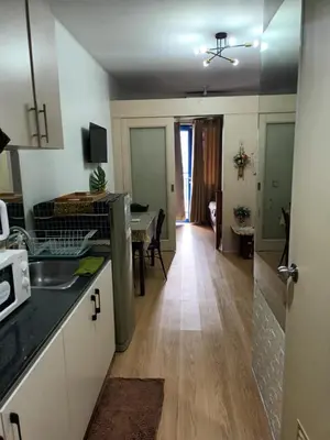 a kitchen with a counter and a dining room at Sea Residences LJ Place in Manila