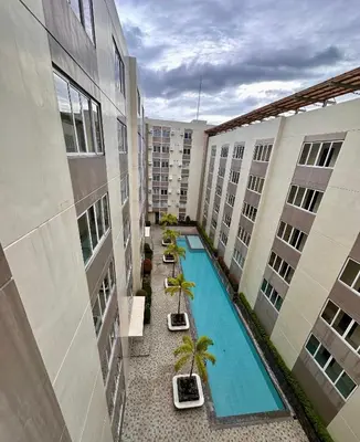 an apartment courtyard with a swimming pool and buildings at South Breeze Stay Near Nuvali, Enchanted kingdom, Tagaytay in Silang