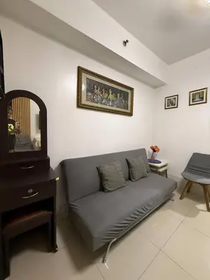 a living room with a couch and a tv at Sea Residences Affordable Staycation Near MOA - by Rose in Manila