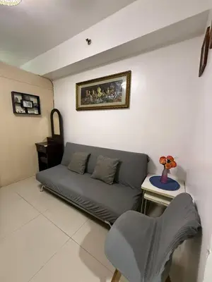 a living room with a couch and a table at Sea Residences Affordable Staycation Near MOA - by Rose in Manila