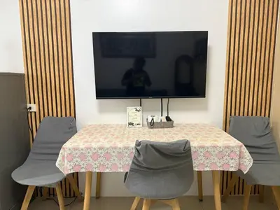 a table with chairs and a tv on the wall at Sea Residences Affordable Staycation Near MOA - by Rose in Manila
