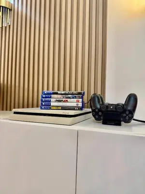 a remote control sitting on top of a table with books at 1BR Bahamas 19th floor, Azure Paraaque in Manila
