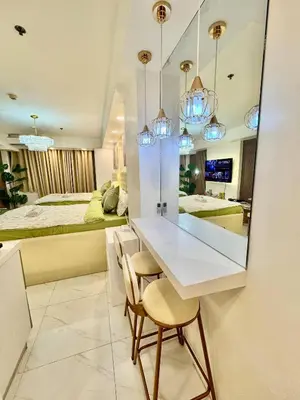 a dining room with a table and two beds at 1BR Bahamas 19th floor, Azure Paraaque in Manila