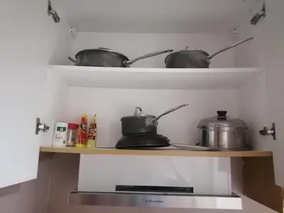 two pots and pans on a shelf in a kitchen at Location perfect staycation with Netflix in Manila
