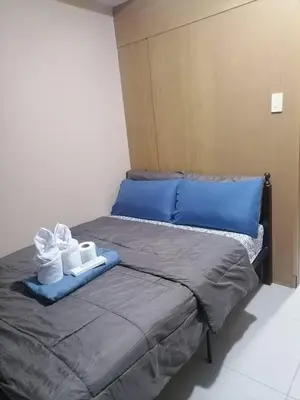 a bed with two towels and two pillows on it at Location perfect staycation with Netflix in Manila